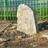 A Valenzano, un piccolo monolite cristianizzato davanti a una cancellata verde
